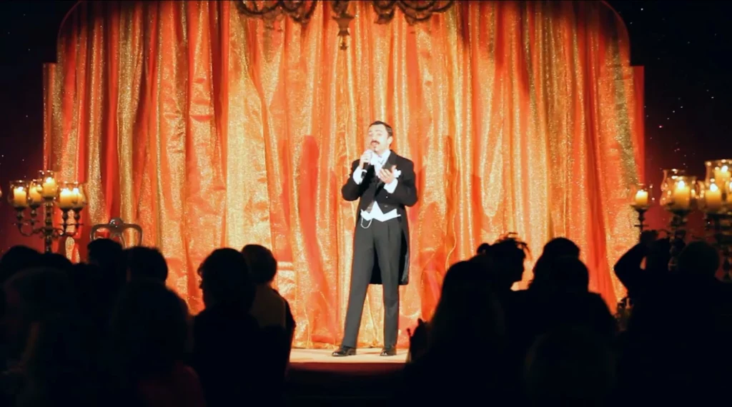 Event emcee Attilio Reinhardt in formal white tie tailcoat with microphone on stage at Ca' Vendramin Calergi during the Venice Carnival official event, Italy.