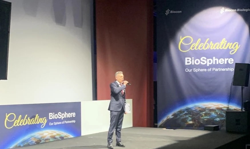 Professional emcee Attilio Reinhardt on stage with microphone and clipboard during the Biocon corporate event at the Alfa Romeo Museum business hall, Milan.