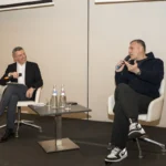 Il presentatore Attilio Reinhardt, seduto a sinistra, intervista Christian Vieri, seduto a destra, entrambi con microfoni in mano sul palco dell'Hotel Sheraton San Siro di Milano.