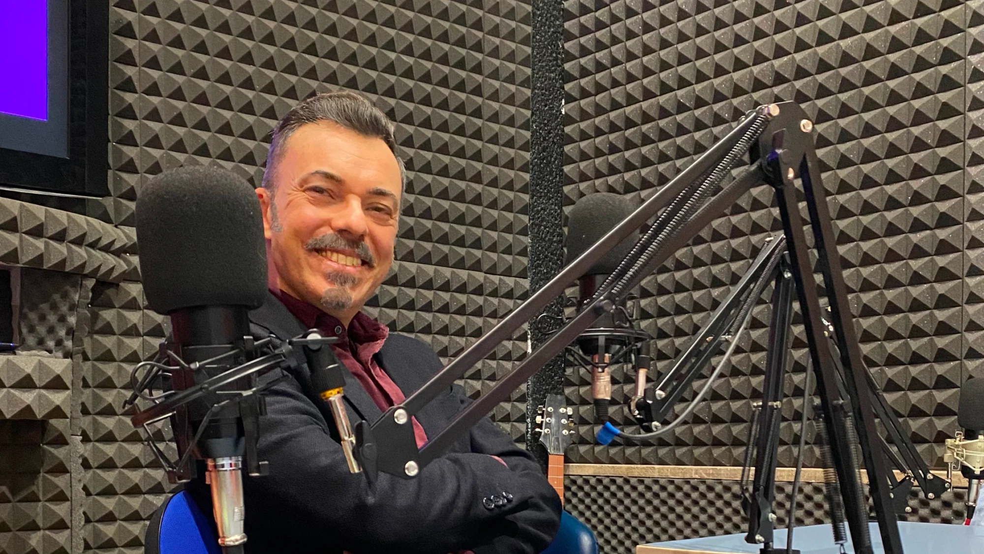 Attilio Reinhardt speaker con microfono in uno studio radiofonico