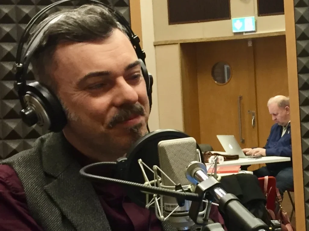 Attilio Reinhardt redattore e conduttore radiofonico. Nella foto, al microfono negli studi della RSI Radiotelevisione Svizzera Italiana a Lugano, Svizzera, nel 2018. Sullo sfondo, l'autore radiofonico e televisivo Paolo Taggi.